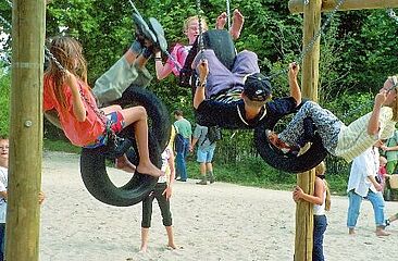 Sechseckschaukel_Lernräume_außen Kinder schaukeln auf Sechseckschauckel im Freien