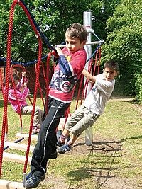 Seilparcours_Lernräume_außen Kinder klettern auf Seilen im Freien