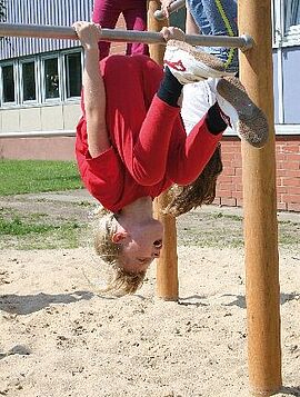 Rundreck_Lernräume_außen Kind turnt am Rundreck im Freien