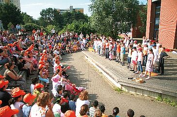 Freilichtforum_Lernräume_außen Kinder sitzen im Halbkreis im Freien