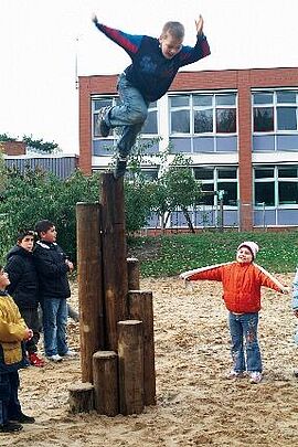Mutspirale_Lernräume_außen Kind springt vom Baumstamm