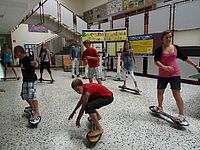 Schüler fahren mit Waveboards in Pausenhalle