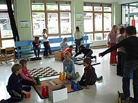 Kinder spielen verschiedene Spiele am Boden