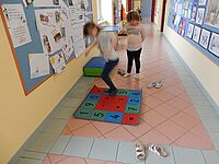 Kinder spielen auf Rechenteppich am Gang