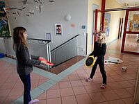 Zwei SchülerInnen spielen Sportdisk am Gang